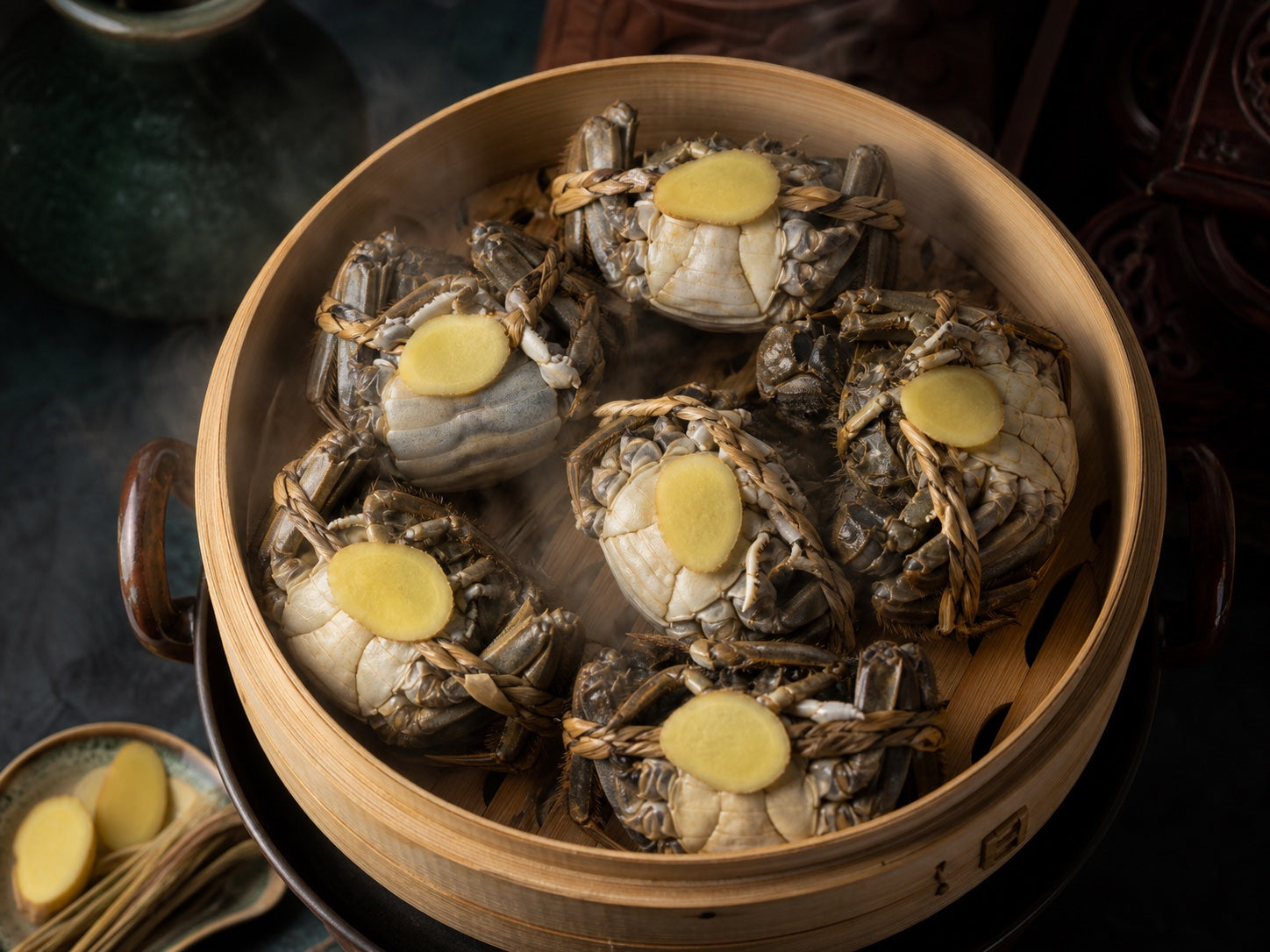 Tied hairy crabs arranged belly side up with ginger slices in a bamboo steamer
